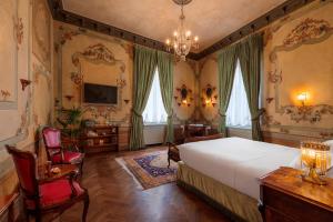a bedroom with a bed and a desk and chairs at Hotel Locarno in Rome