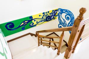 a wooden staircase with a surfboard on the wall at 臺東火車站 黎亞兒民宿Liyar House 青旅客棧 in Taitung City