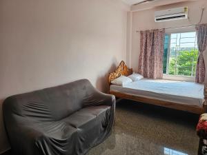 a living room with a couch and a bed and a window at Hotel Seven Heaven in mayapur