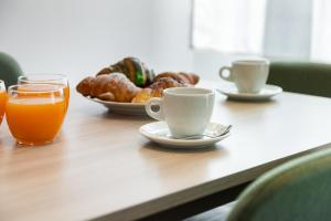 a table with cups of coffee and a plate of pastries at NEW Luxury Flat 10min P Nuova in Turin +21 photos