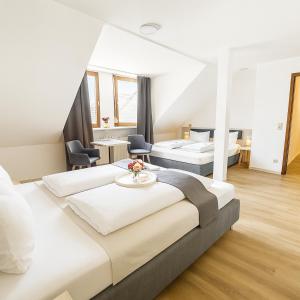 ニュルンベルクにあるHotel Daucherのベッド2台とテーブルがあるホテルの部屋 +30枚の写真