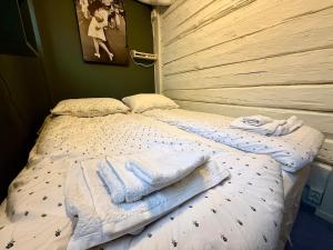 a bedroom with a bed with towels on it at Rustic Retreat Apartment, Central & free parking ! in Trondheim