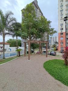 een park met een boom voor een gebouw bij Riocentro, Projac, Parque Olímpico, apartamento completo com vaga! in Rio de Janeiro