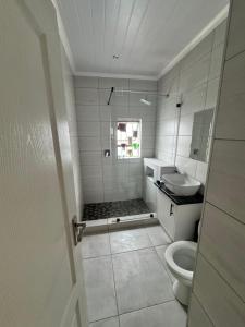 a white bathroom with a toilet and a sink at Da Silva Residence in George +2 photos