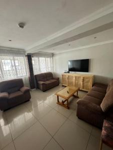 a living room with couches and a flat screen tv at Da Silva Residence in George