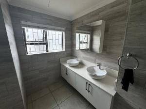 a bathroom with two sinks and a mirror at Da Silva Residence in George