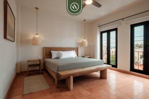 a bedroom with a bed and a bench and windows at Centric 3BR Condo in Downtown in Oaxaca in Oaxaca City +27 photos