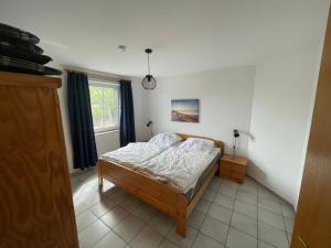 a bedroom with a bed and a window at Ferienwohnung Matschak OG links in Fehmarn