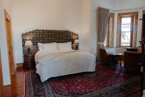 a bedroom with a large bed and a rug at Old Posthouse Guest Accommodation in Ladismith +58 photos
