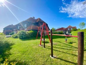 a playground in a yard in front of a house at Ferienwohnung Matschak OG links in Fehmarn
