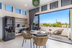 a dining room with a table and chairs and a large window at Amazing Studio with Rooftop Pool - 5 min to Marina in Los Médanos Partidos