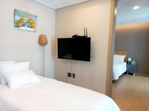 a bedroom with two beds and a flat screen tv at Haeundae station 3min# seashore 3min# high floor view# luggage storage# flexible checkin& out# family in Busan