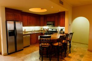 a kitchen with wooden cabinets and a stainless steel refrigerator at Las Mañanitas LM F4404 in San José del Cabo