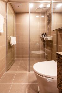 a bathroom with a toilet and a glass shower at Haeundae station 3min# seashore 3min# high floor view# luggage storage# flexible checkin& out# family in Busan +30 photos