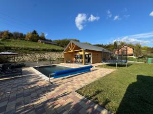 a backyard with a swimming pool and a house at Holiday House Novus in Selno