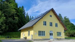 a yellow house with a black roof at Appartements Dorner, Semmering in Steinhaus am Semmering