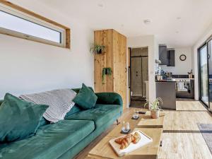 Una sala de estar con un sofá verde y una mesa. en 1 Bed in Worcestershire 89032, en Abberley