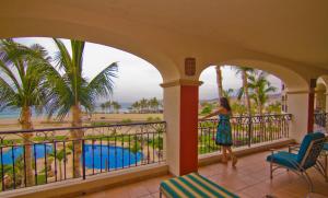 a woman standing on a balcony looking out at a pool at Las Mañanitas LM E3303 in San José del Cabo