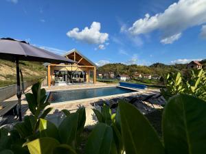 a house with a swimming pool and an umbrella at Holiday House Novus in Selno