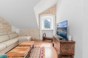 a living room with a couch and a tv at Sponza House in Trstenik