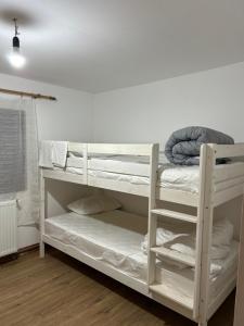 SăgageaにあるMontain Cabin Apuseniの白い二段ベッドが備わる客室です。