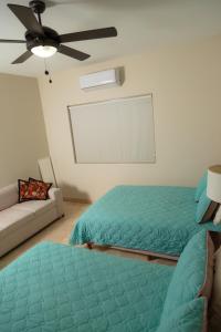a bedroom with a bed and a couch and a ceiling fan at Baja Toms B311 - 3 Bedrooms with a wonderful view in El Tule