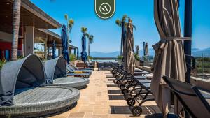 een rij stoelen en parasols op een patio bij Cozy Apt with Private Terrace - Pool - King Beds in Nuevo Vallarta 