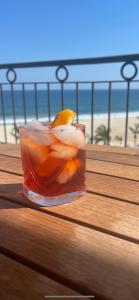 a drink sitting on top of a wooden table with the beach at Tortuga Bay TBB 2502 in San José del Cabo