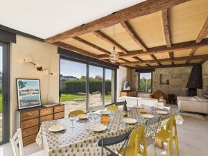 a dining room with a long table and yellow chairs at Vue rivière - grande maison et jardin pour 10 in Pont-lʼAbbé
