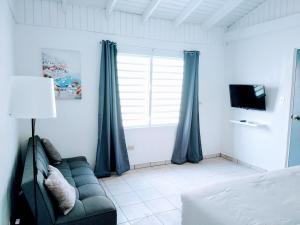 a living room with a couch and a window at Downtown Beach Retreat in Luquillo