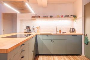 a kitchen with white cabinets and a wooden counter top at Naar Zee op Ameland in Buren