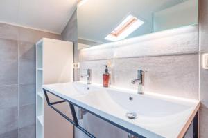 a bathroom with a white sink and a mirror at Naar Zee op Ameland in Buren