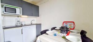 a small kitchen with a table and a microwave at Appartement dans résidence avec piscine in La Couarde-sur-Mer +2 photos
