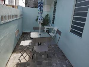 a table and chairs on a balcony with a window at Downtown Beach Retreat in Luquillo