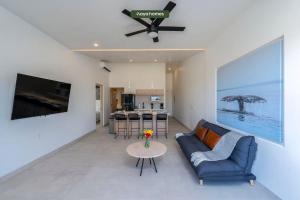 a living room with a blue couch and a table at Amazing Apt with City View - Rooftop Pool in Los Médanos Partidos