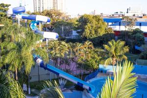 a water slide at a resort with palm trees at Hotel Vilage Inn Ribeirão Preto & Convenções by Nacional Inn in Ribeirão Preto