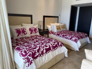 a bedroom with two beds with red and white blankets at Tortuga Bay TBB 2502 in San José del Cabo +17 photos