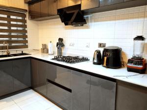 a kitchen with a stove and a counter top at Bextro Suites Magodo Phase 1 Cozy 2 Bedroom Apartment with Washing Machine in Iseri-Oke
