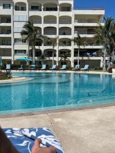 a person laying on a chaise lounge next to a swimming pool at Tortuga Bay TBB 2502 in San José del Cabo