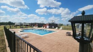 a swimming pool on a patio with a fence at New Pool, Hot Tub, Patio, Pickleball, Cornhole in Fredericksburg +17 photos