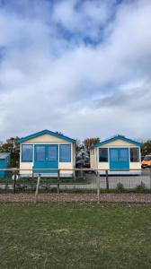 two houses with blue windows on a fence at Aan de Waterspiegel in Aagtekerke