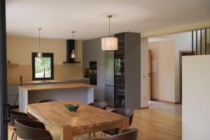 una cucina e una sala da pranzo con tavolo e sedie in legno di Quinta da Fenteira - Casa Lima a São Jorge
