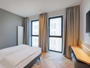 a hotel room with a bed and a large window at B&B HOTEL Berlin Airport-Nord in Berlin