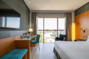 a hotel room with a bed and a table and chairs at Eurostars Puerta Madrid in Madrid +17 photos