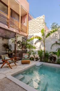 a house with a swimming pool next to a building at Entorno Tulum - Luxury Villas in Tulum