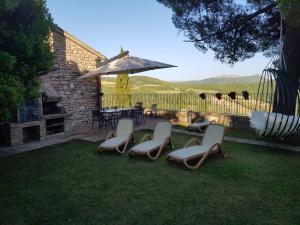 a group of chairs and a table and an umbrella at La Terrazza di Collepino in Collepino