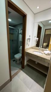 a bathroom with a toilet and a sink and a mirror at Enjoy Olímpia Park Resort in Olímpia