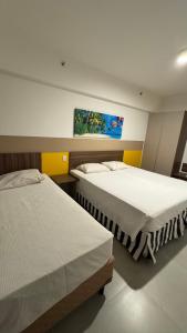 a bedroom with two beds and a painting on the wall at Enjoy Olímpia Park Resort in Olímpia