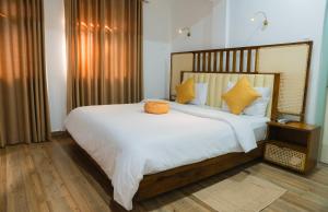 a bedroom with a large white bed with yellow pillows at The Living Villa in Badulla +48 photos