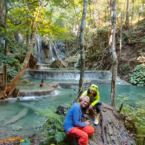 a woman and child sitting in front of a waterfall at Whale shark Sumbawa Tour in Sumbawa Besar